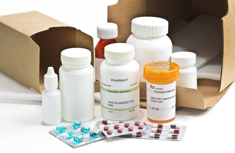 Different prescription drugs in front of corrugated boxes; medical packaging company; packaging for medical devices; pharmaceutical packaging