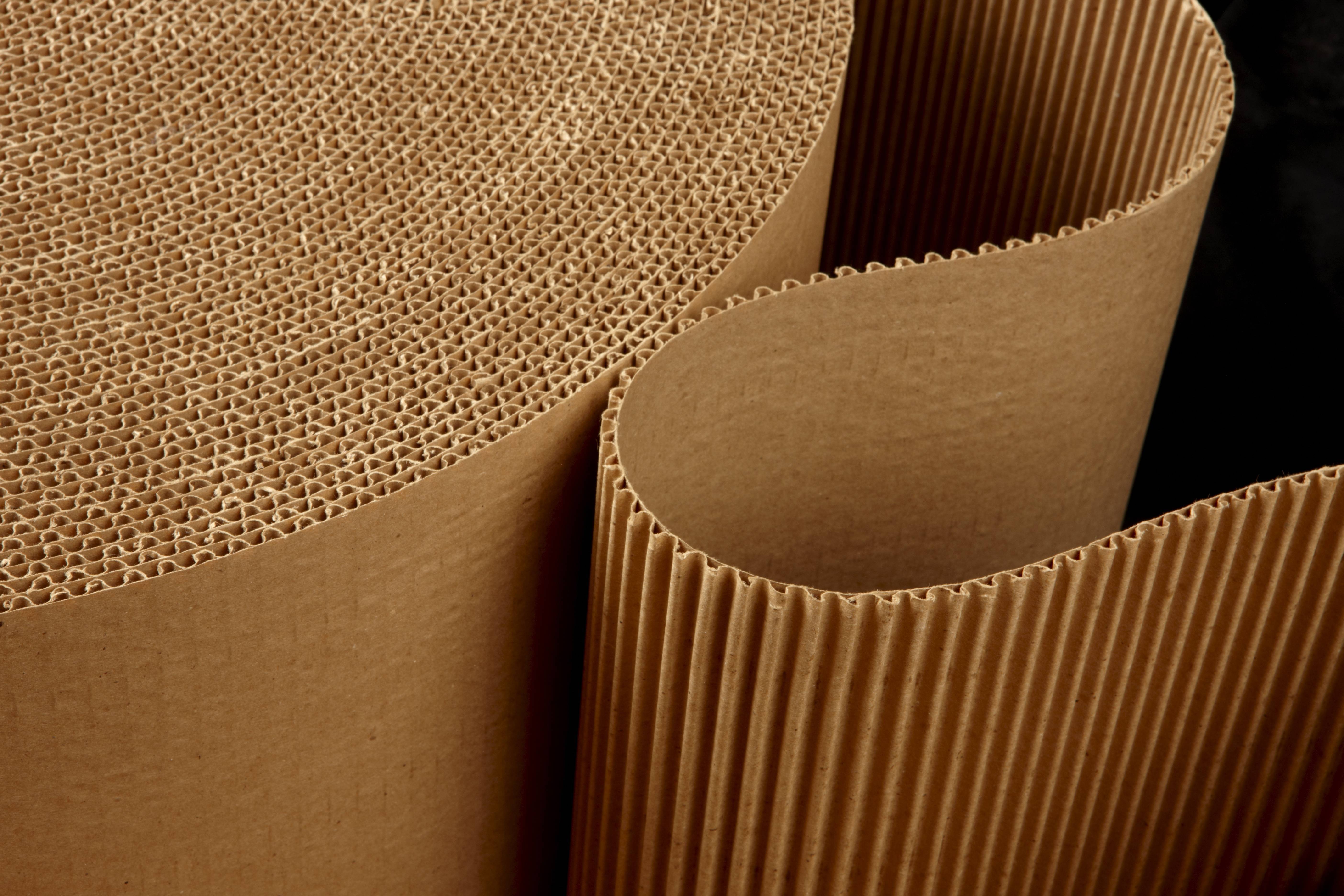 close up shot of corrugated packing material uncurling on black background