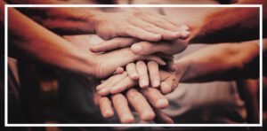 Grupo de manos apiladas unas sobre otras para trabajar en equipo.