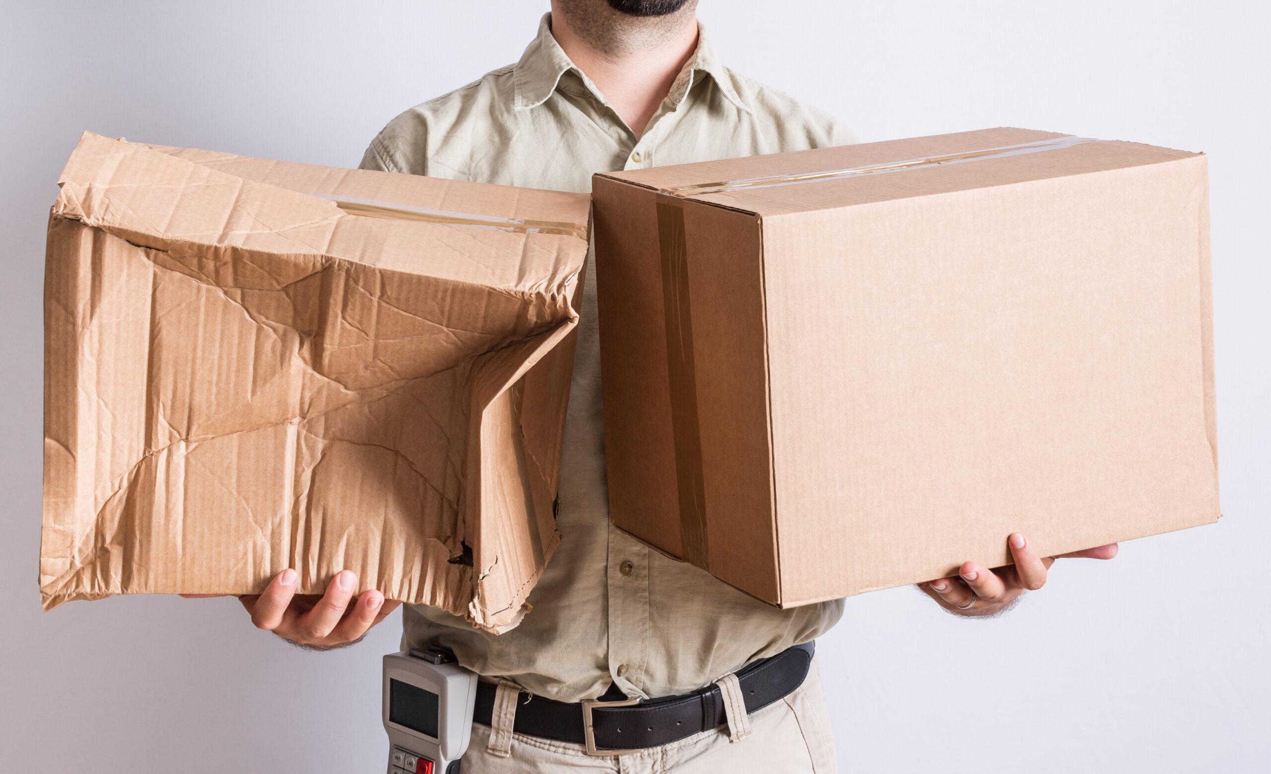Delivery person holding Damaged Packaging and plain brown box; Damaged packages; shipping damage