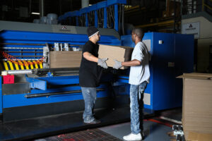 Premier employees working on corrugated box machine; corrugated box manufacturers; packaging solutions; packaging distributor