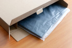 Unpacking new blue laptop at wooden desk