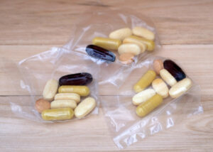 Servings of tablets of different sizes and colors in bags.