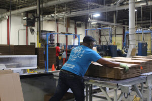 Premier employee in production plant stacking boxes