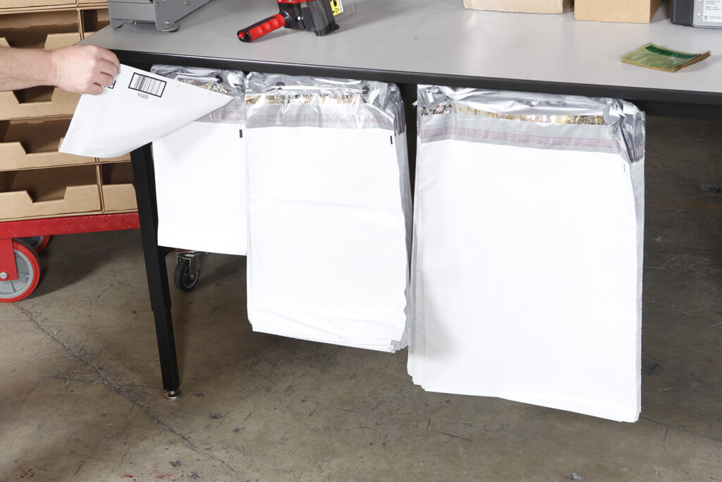 Different sized poly mailers on wickets in a pack station; automatic bagger; automated bagging machine; auto bagger