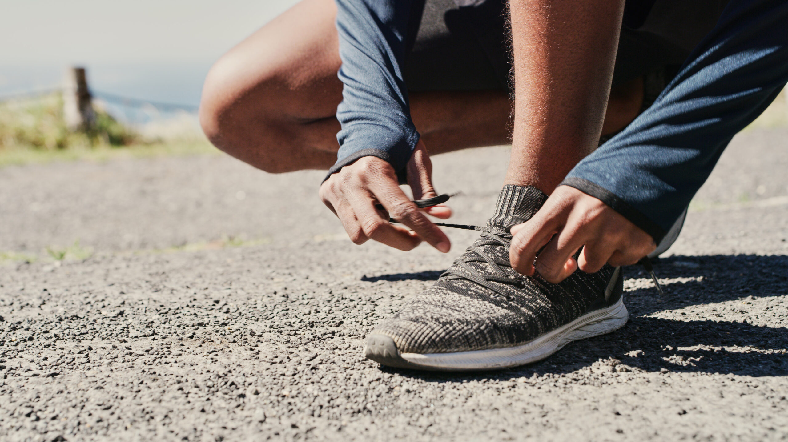Cropped shot of a man tying his shoelaces while out for a run.