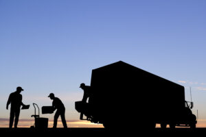 Varios trabajadores descargan un camión a primera hora de la mañana.