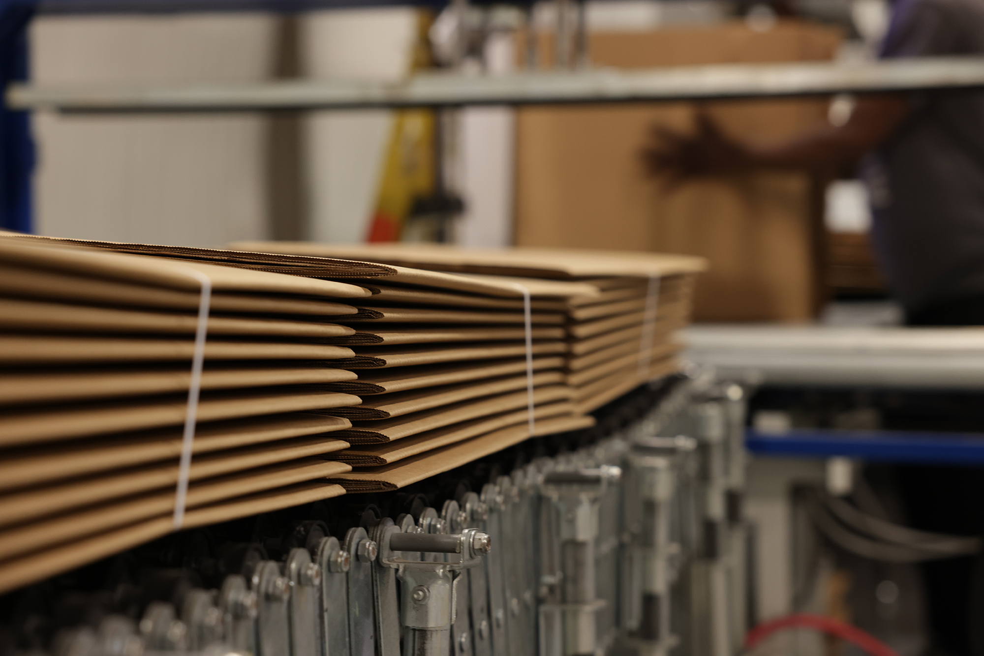 Close up photo of bundled corrugated boxes on conveyor belt; custom corrugated boxes; Premier Packaging boxes