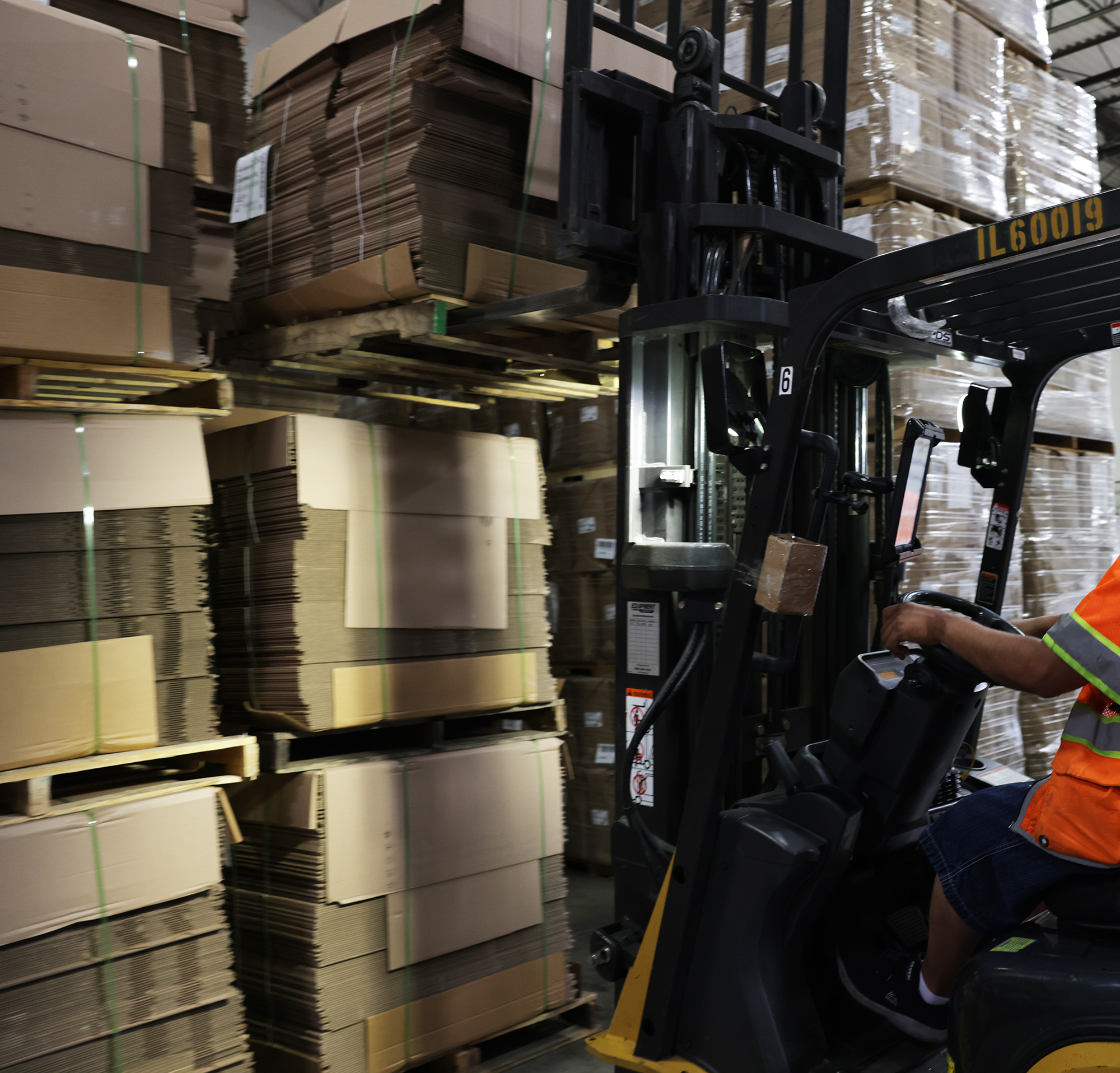 Forklift moving corrugated boxes inside distribution center