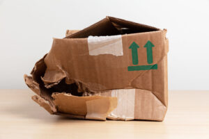 Caja de cartón rota, arrugada y vacía. Concepto de embalaje dañado