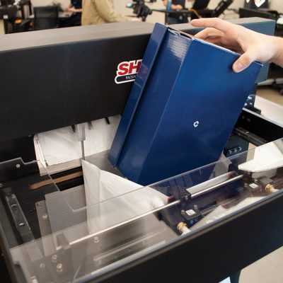 Sharp poly bagging machine with bag in box Sharp poly bagging machine, man putting box into bag; Warehouse equipment; packaging equipment; packaging automation equipment; automatic packaging machinery