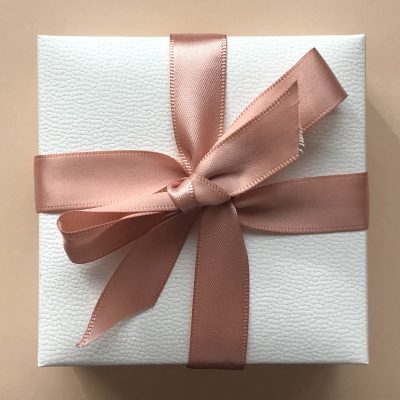 Close up of a white luxury gift box with a pink ribbon; packaging products; boxes for packaging products; premium packaging solutions