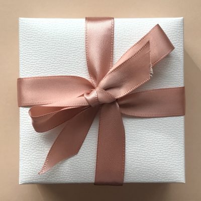 Luxury packaging box with ribbon Close up of a white luxury gift box with a pink ribbon; packaging products; boxes for packaging products; premium packaging solutions and packaging supplies